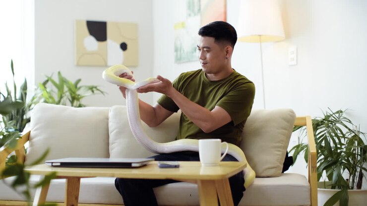 Man holding snake indoors