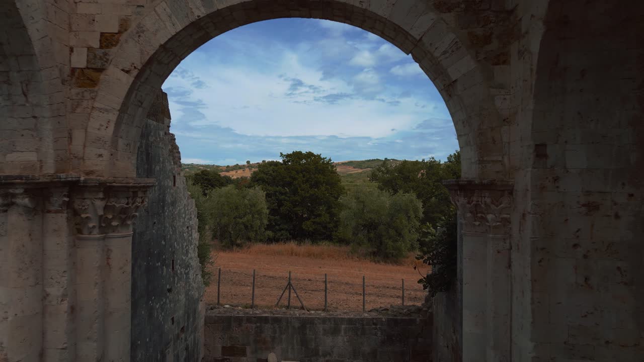 volando a través de abbazia di san bruzio, una antigua ruina dañada de una iglesia de abadía de monasterio medieval abandonada en toscana del siglo xi rodeada de olivos en italia