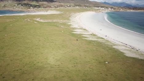 Inclinación-Aérea-Hacia-Arriba:-Prados-Y-Playa-De-Arena-En-Connemara,-Irlanda,-Costa-Del-Océano-Atlántico