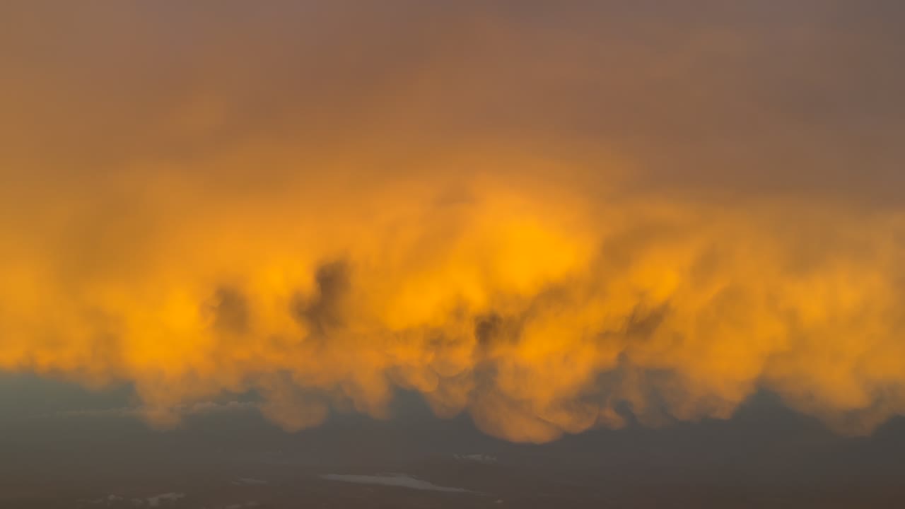 POV flying under a golden color cloud illuminated by the dawn light as seen by the pilots of a jet airplane. Immersive pilot’s perspective. 4K 60FPS