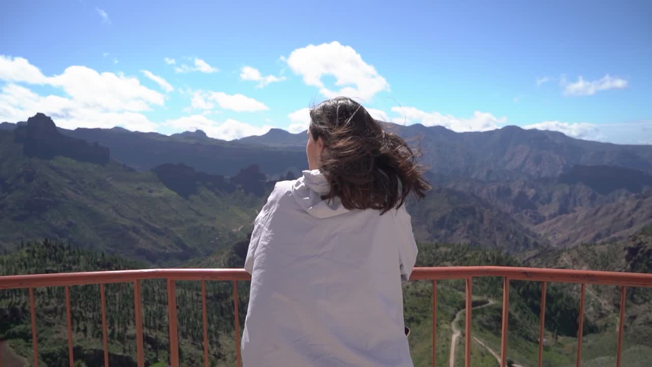Woman looking at mountains landscape at viewpoint in Artenara, Gran Canaria, Spain