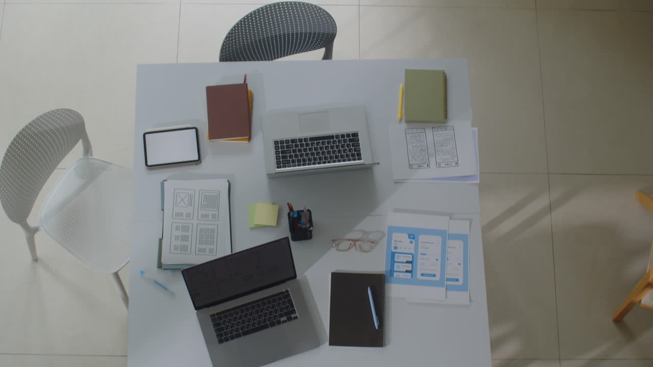 Laptops, Tablets and Documents on Worktable of IT Specialists