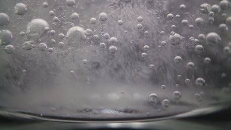 Glas-Mit-Klarem,-Sprudelndem-Vitaminwasser-Auf-Dunklem-Hintergrund