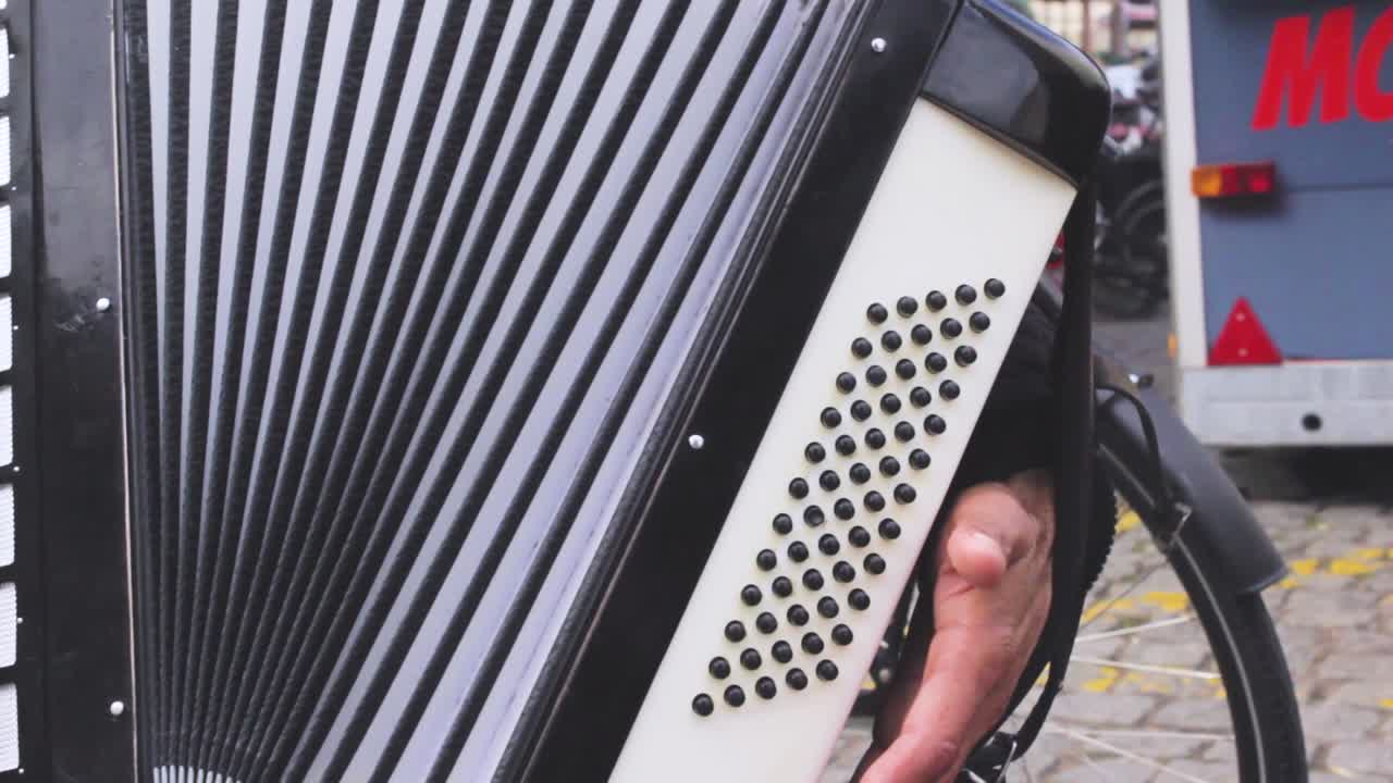 Close-up shot of a street musician's hand playing the accordion. Copenaghen, Denmark. Front view