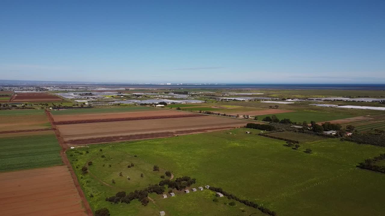 드론은 배경에 산업 건물과 함께 녹색 농업  ⁇ 도크를 촬영했습니다.
