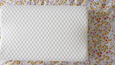 white memory foam pillow on floral bedding
