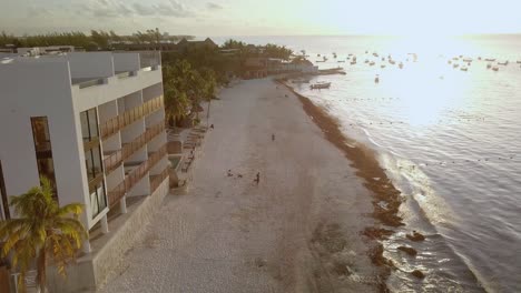 AERIAL---Beautiful-sunset,-boats-afloat-in-front-of-the-beach-in-Cancun,-Mexico