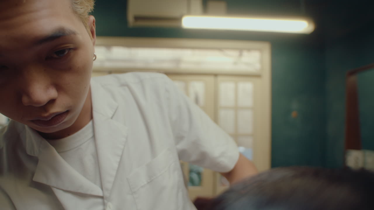 Asian Barber Examining Haircut of Client and Checking Evenness