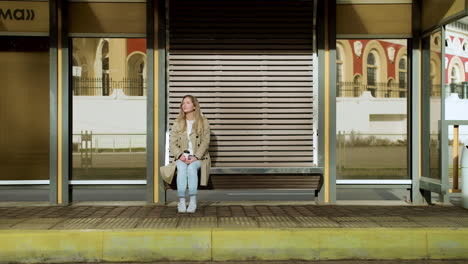 young woman sitting at bus stop