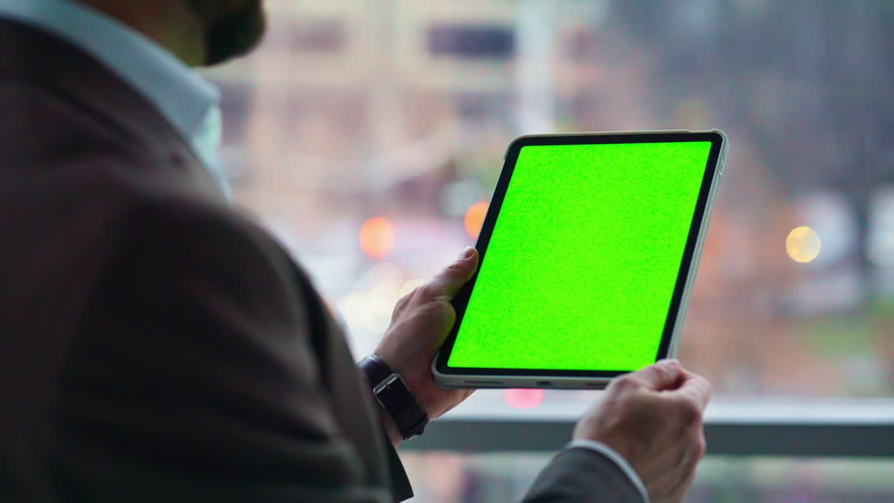 Professional tapping greenscreen tablet standing office panoramic window closeup
