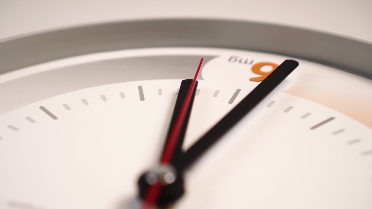 tiempo pasando con una segunda mano roja y manos negras de minutos y horas en un dial blanco con patrones naranja y gris