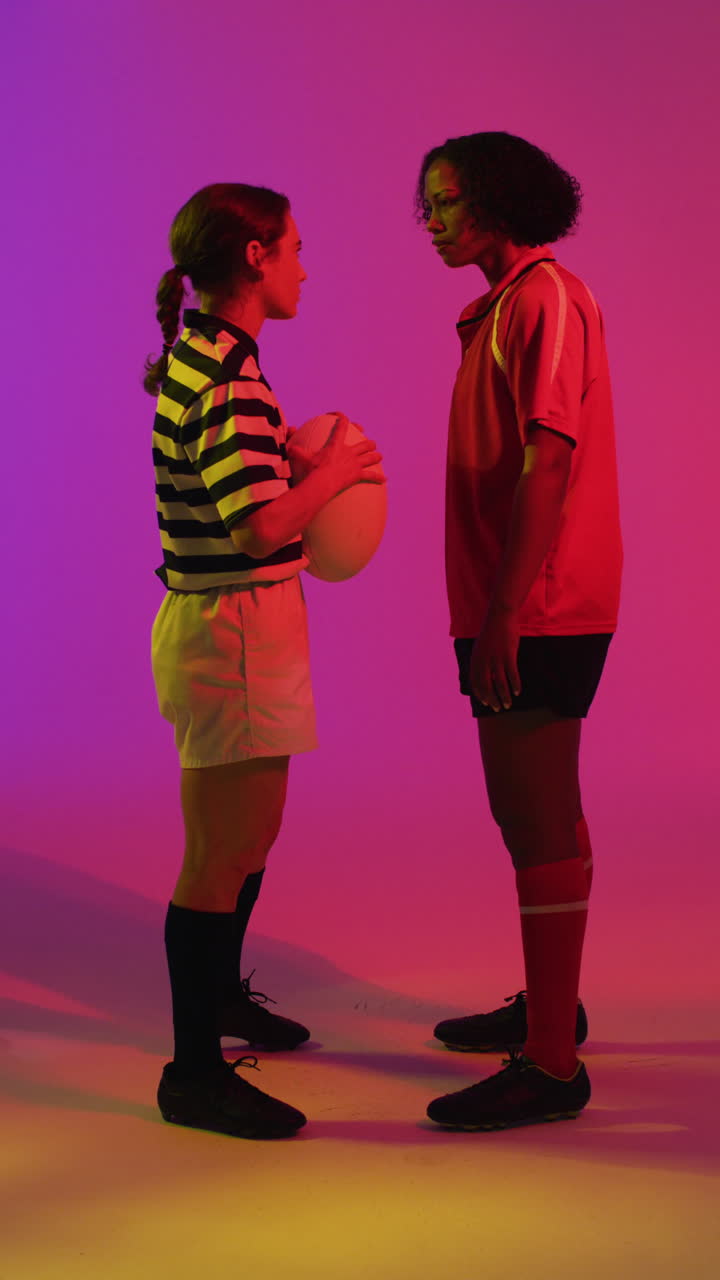 video vertical de diversas jugadoras de rugby con pelota de rugby sobre iluminación rosa neón