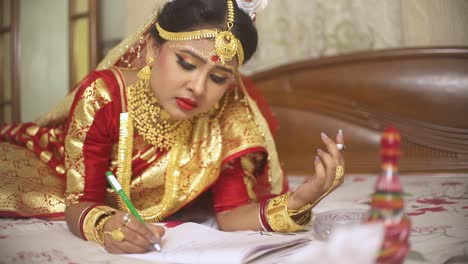 sad young indian bride smoking cigarette and writing suicide note at home before arranged marriage, golden jewellery