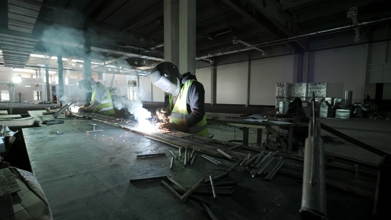los soldadores profesionales están trabajando en la fábrica con equipos de seguridad. fabricación de metalurgia, proceso industrial.