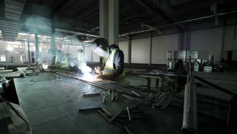 professional welders are working in the factory wearing safety equipment. metalwork manufacturing, industrial process.