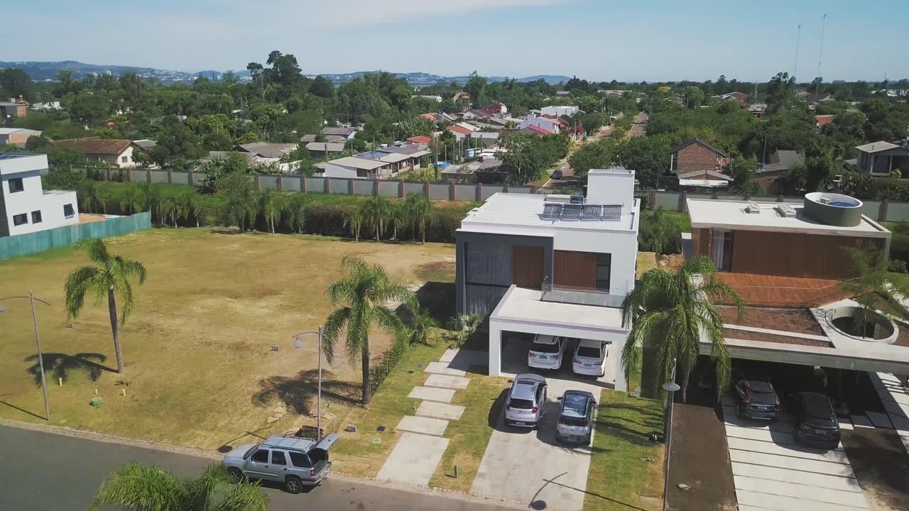 Beautiful Houses With Concrete And Glass Wallings Surrounded By Lush Palm Trees In Ponta Da Figueira, Brazil, Cars Parked At The Garage On A Hot Sunny Weather - Aerial Shot
