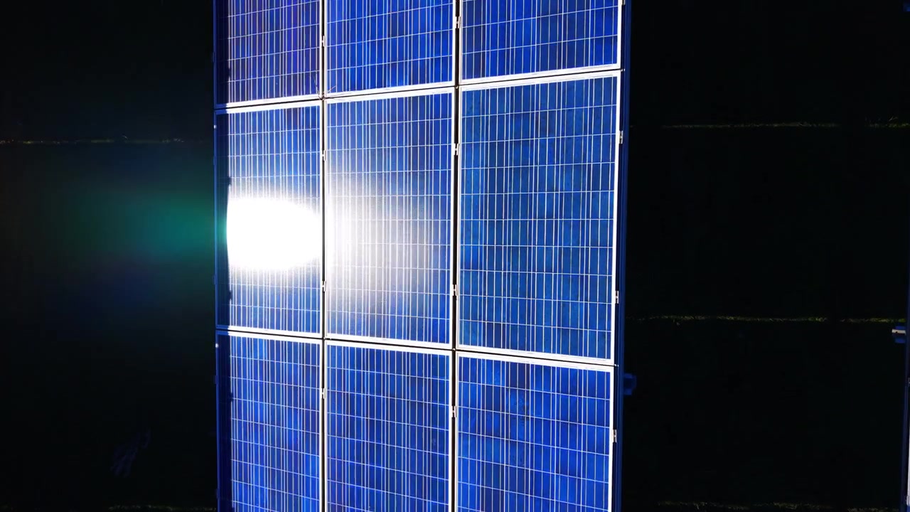Dettaglio di celle di pannelli solari con bagliore solare intenso. Una vista ravvicinata mostra una griglia fotovoltaica blu che brilla sotto un'intensa luce riflessa