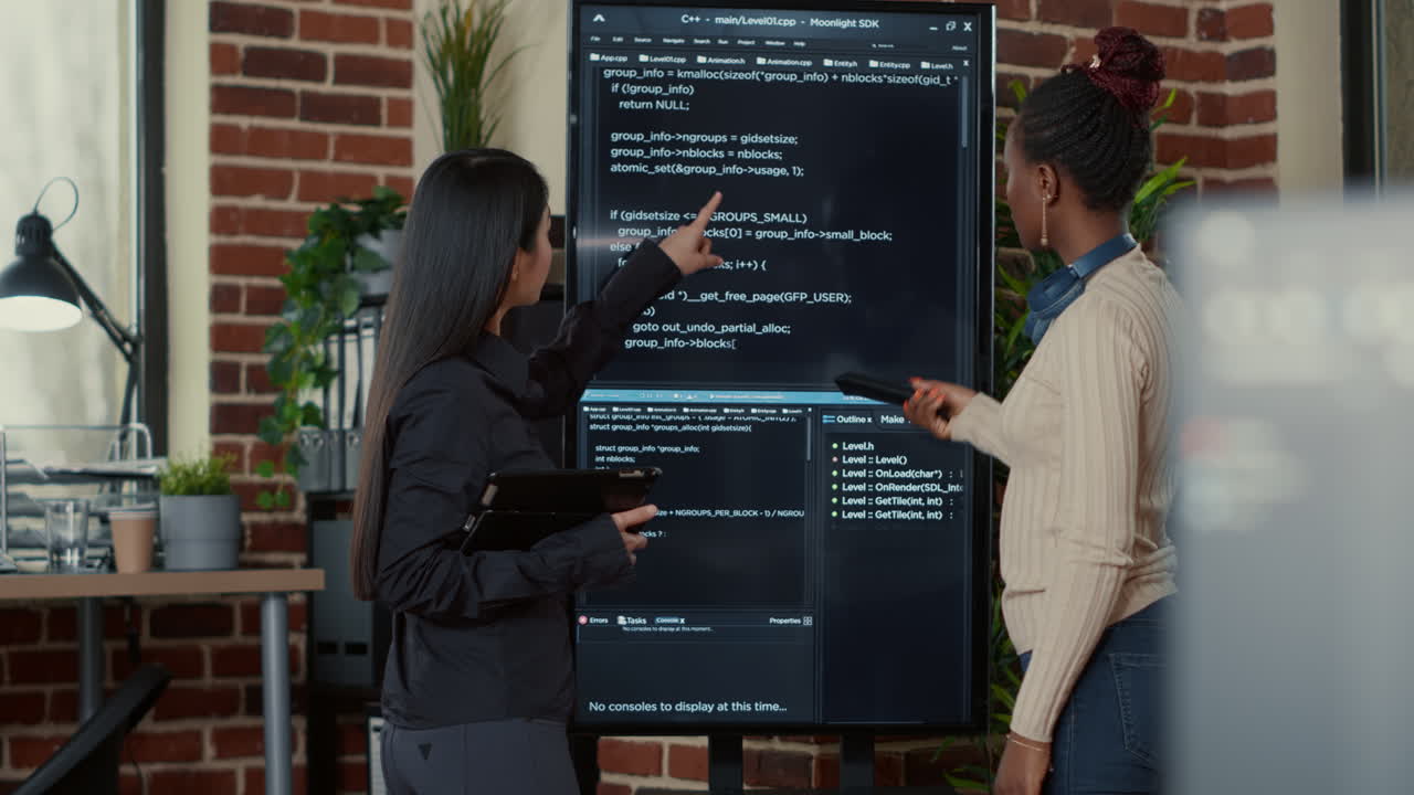 Team of programmers analyzing code on wall screen tv looking for bugs and errors