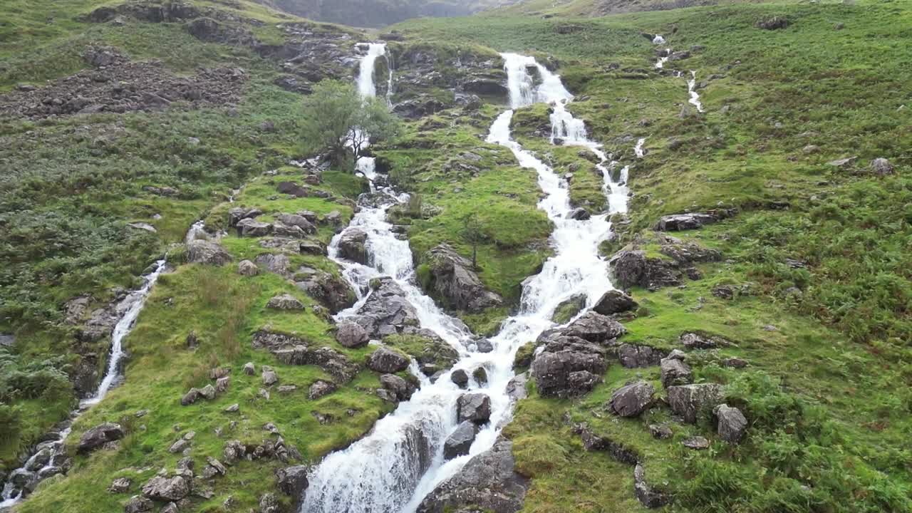 la furiosa cascada que cae en cascada por la montaña es en cámara lenta después de días de fuertes lluvias, dron aéreo parte 6, alta montaña, buttermere, distrito de los lagos, reino unido