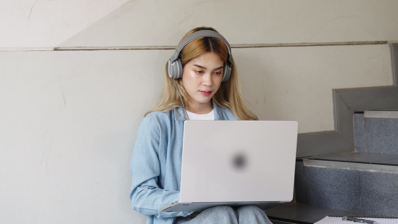 Two Asian girls student partners are working on a laptop help study together