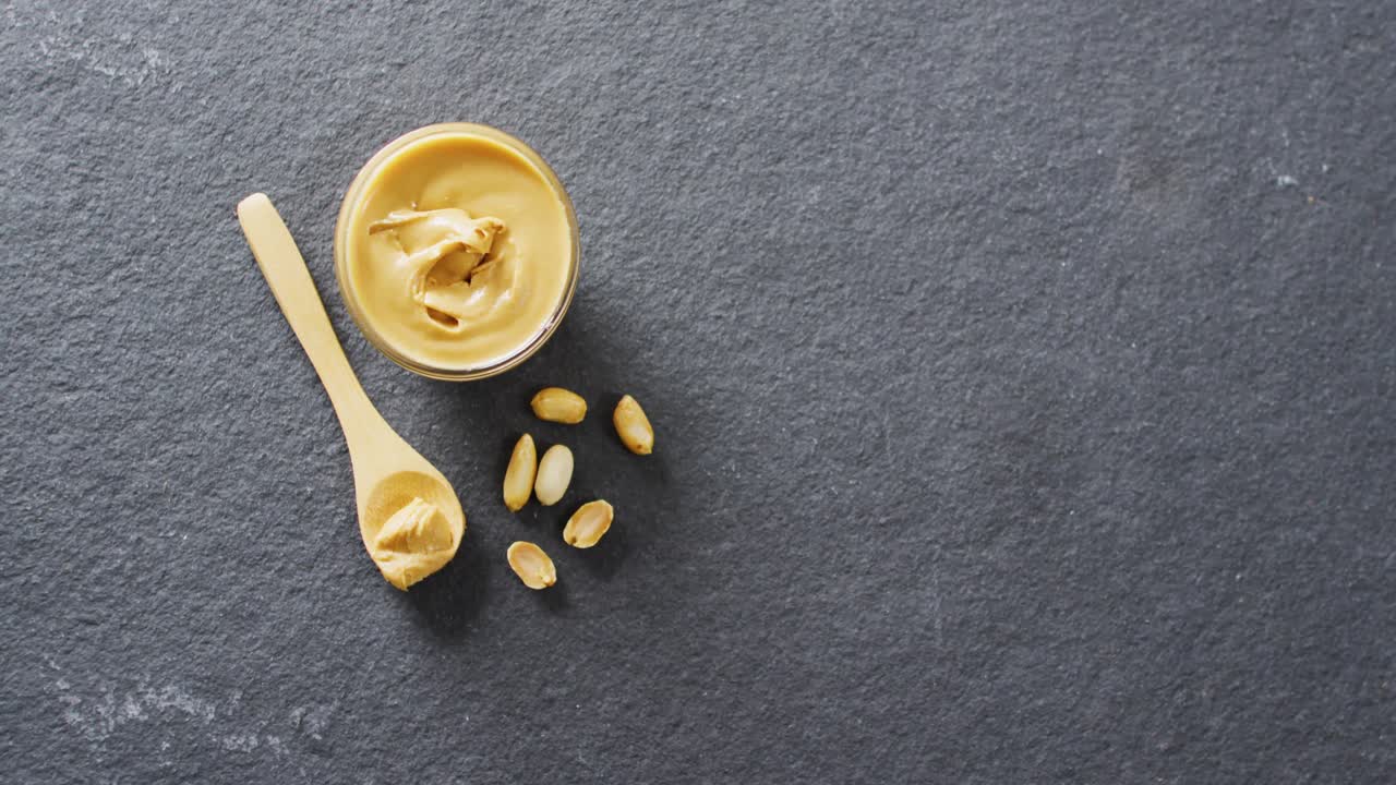 Video of close up of peanut butter on gray background