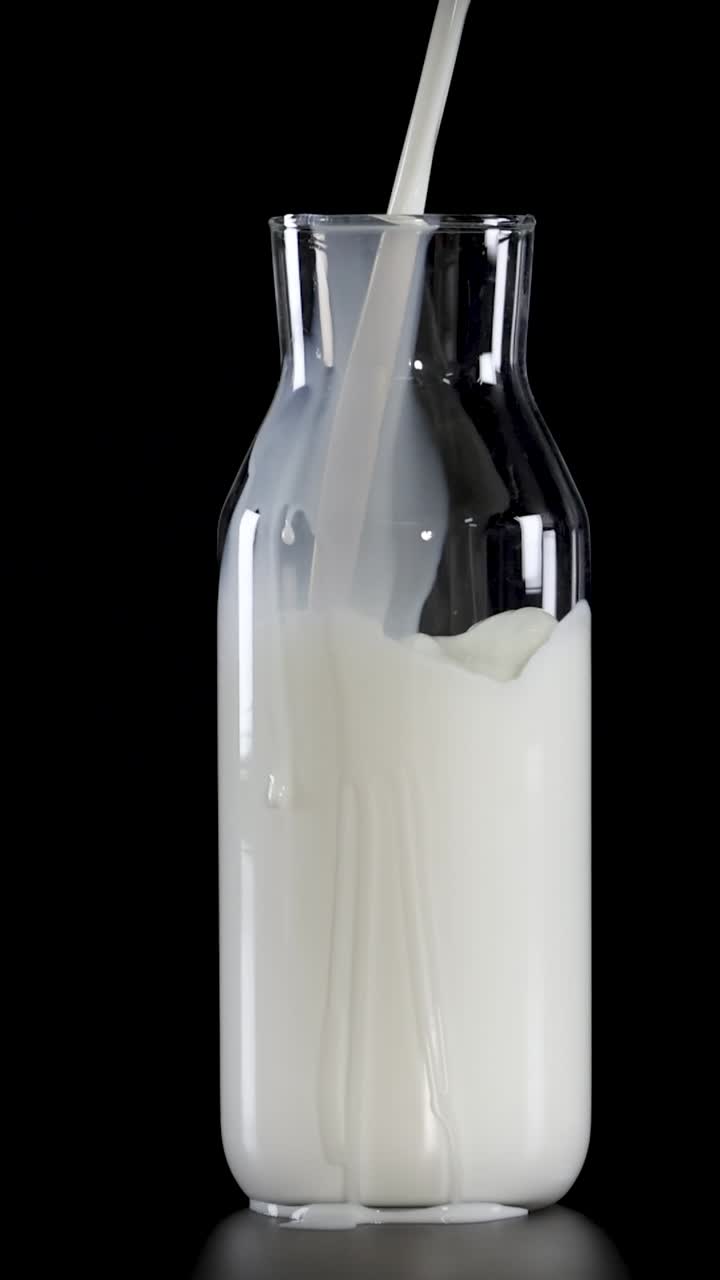 우유 가 유리 병 에 어지고 있는 것