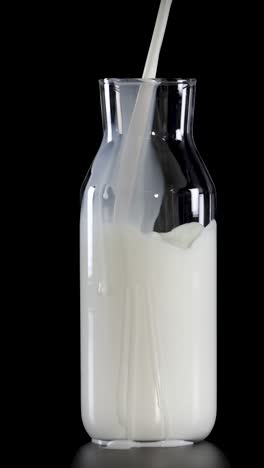 la leche se vierte en botellas de vidrio con pajitas