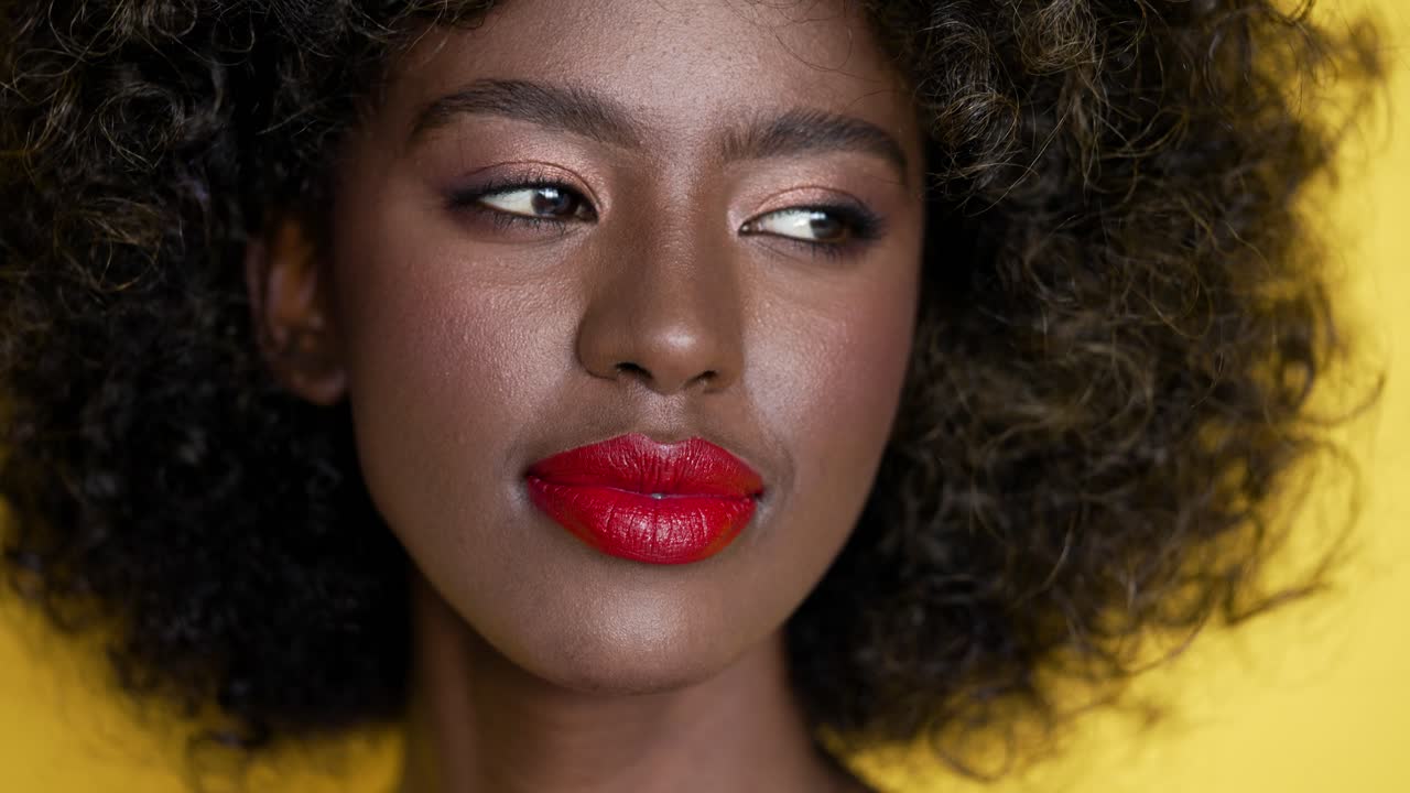 retrato de una mujer con cabello rizado y lápiz labial rojo