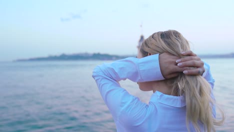 slow motion:beautiful girl enjoys sunset view of bosphorus with view of maiden tower at background in istanbul