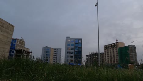 Low-angle-shot-of-rows-of-office-buildings-in-Bahria-Town,-Karachi,-Pakistan-with-cloud-movement-in-timelapse-during-evening-time