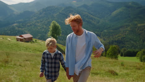 Padre-Hijo-Hablando-Al-Aire-Libre-Caminando-Por-La-Ladera-De-La-Montaña.-Ocio-Familiar.