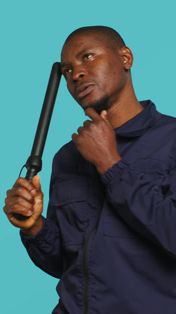 Thoughtful African American Man Holding Baton on Blue Background