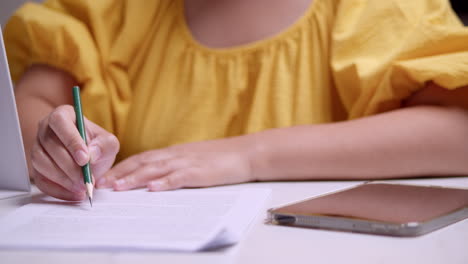 Toma-Panorámica-De-Detalle-De-Manos-Femeninas-Estudiando-Para-El-Examen,-Destacando-Información-Importante