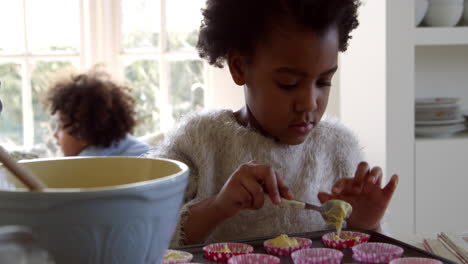 Girl-Putting-Mixture-Into-Cake-Cases-With-Father-Shot-On-R3D