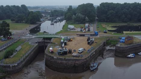 Luftaufnahme-Spike-Island-Council-Arbeiter-Entfernen-Auferstehungskonzert-Barrieren-Aus-River-Canal-Park-Orbit-Langsam-Rechts