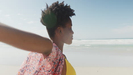 Happy-african-american-woman-with-arms-wide-on-sunny-beach