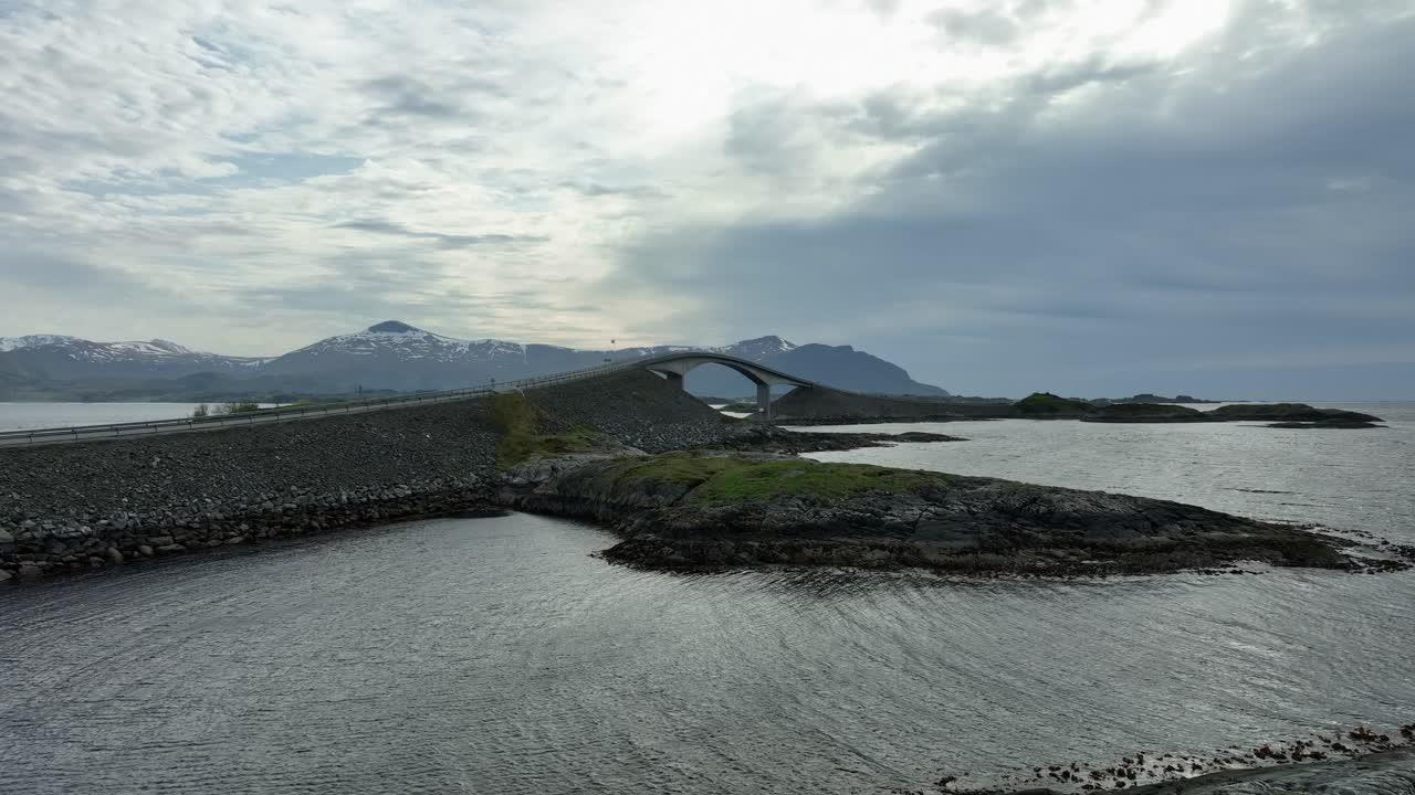 해가 지는 저녁에 대서양 도로를 보여주는 천천히 앞으로 움직이는 항공 - 프레임 중간에 있는 storseisundet 다리