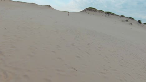 Toma-Aérea-De-Una-Niña-Corriendo-En-Las-Dunas-De-Arena-Caliente-Y-Senderos-En-El-Sendero-Dune-Shacks-En-Provincia,-Cape-Cod,-Massachusetts