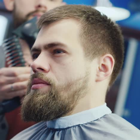 a young stylish man with a beard visits men's salon