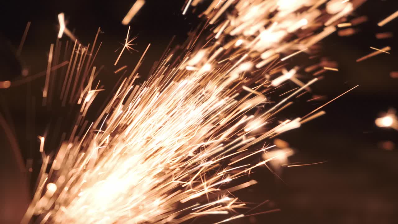 muchas chispas de una sierra de trabajo en la noche