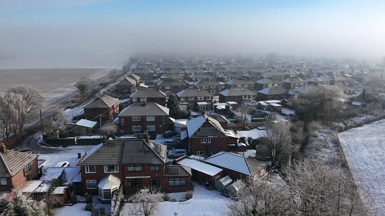 Frosty morning aerial view rising over small town neighbourhood houses with mist atmosphere
