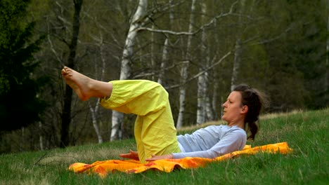 Yoga and pilates exercises on the meadow in the forrest.