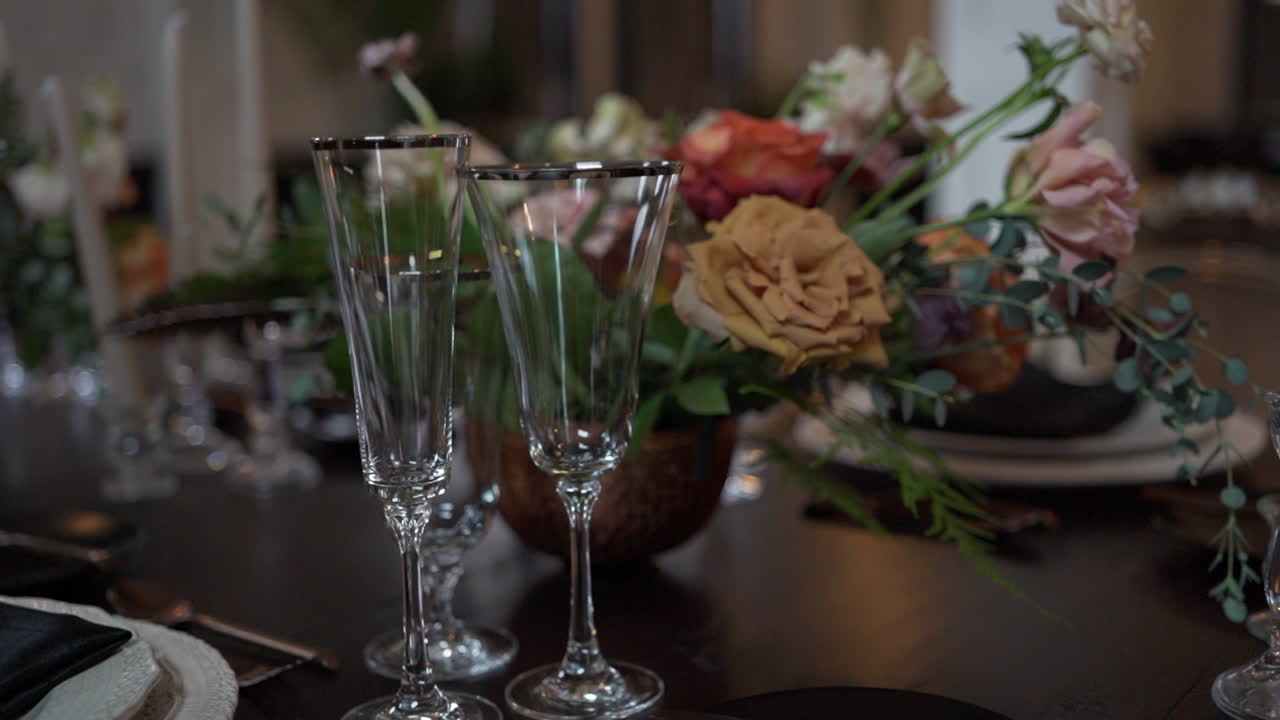 크리스탈 유리잔과 어두운 학술 장소에서 은 식사 파티를위한 어두운 꽃 배열