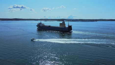 Lancha-Rápida-Y-Barco-De-Carga-Navegando-En-El-Océano-Cerca-De-Lysekil-En-Bohuslan,-Suecia