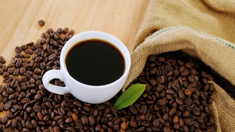 Coffee-cup-with-coffee-beans-and-leaf