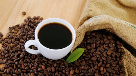 coffee cup with coffee beans and leaf