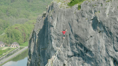 Athlete-trying-to-balance-on-slack-line-over-cliff