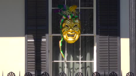 a mardi gras mask is displayed in a window in new orleans