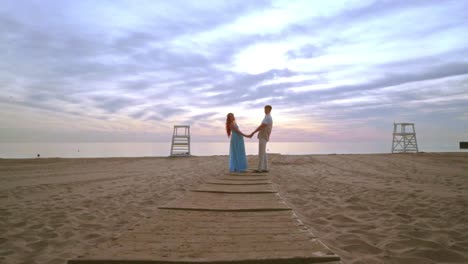 Pareja-Tomados-De-La-Mano-En-La-Playa-Del-Mar.-Amor-Pareja-Playa-Amanecer.-Pareja-Embarazada