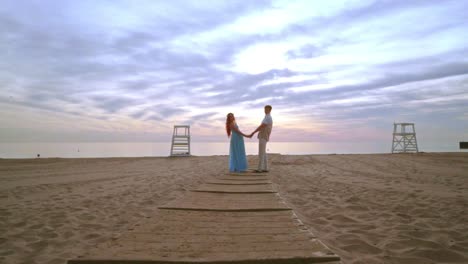 pareja cogida de la mano en la playa. pareja de amor en la playa amanecer. pareja embarazada